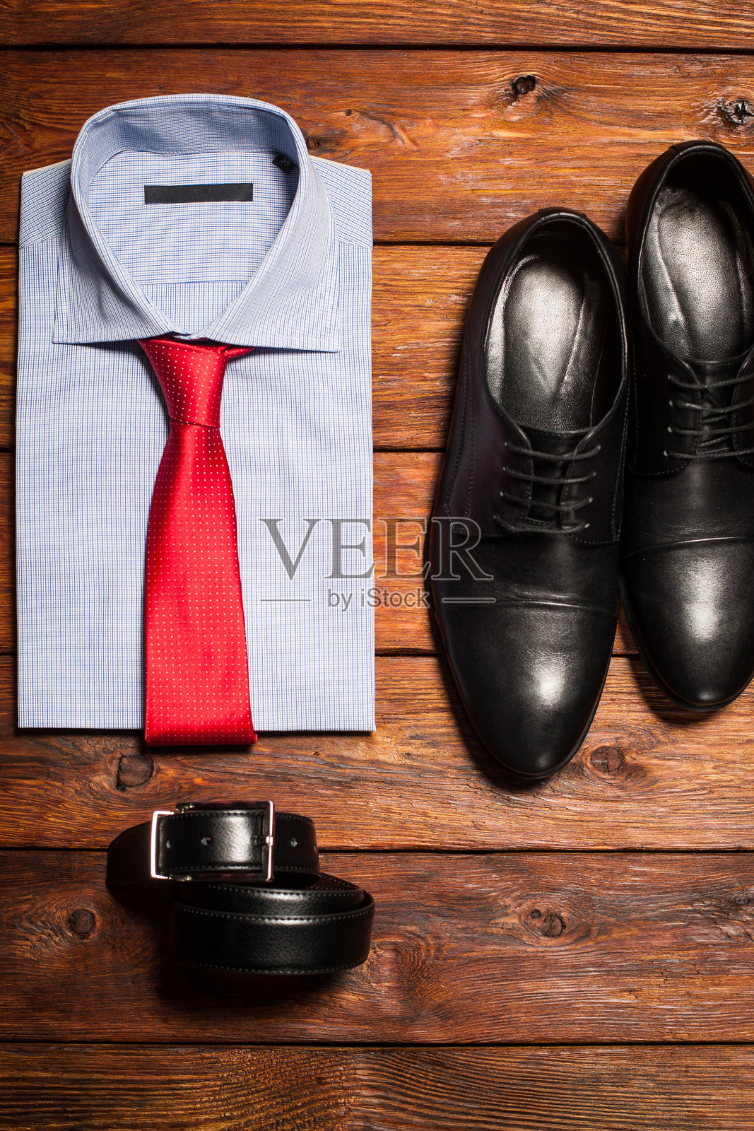 衬衫，鞋子和皮带在一个木制的背景照片摄影图片