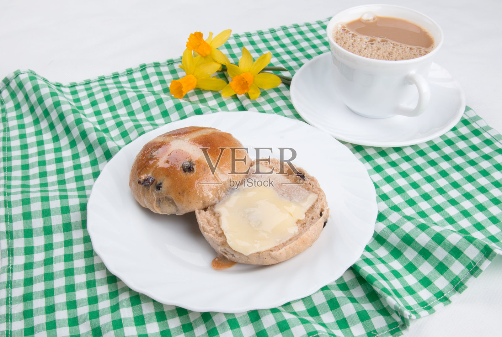 热十字面包切和黄油与绿色格子布照片摄影图片