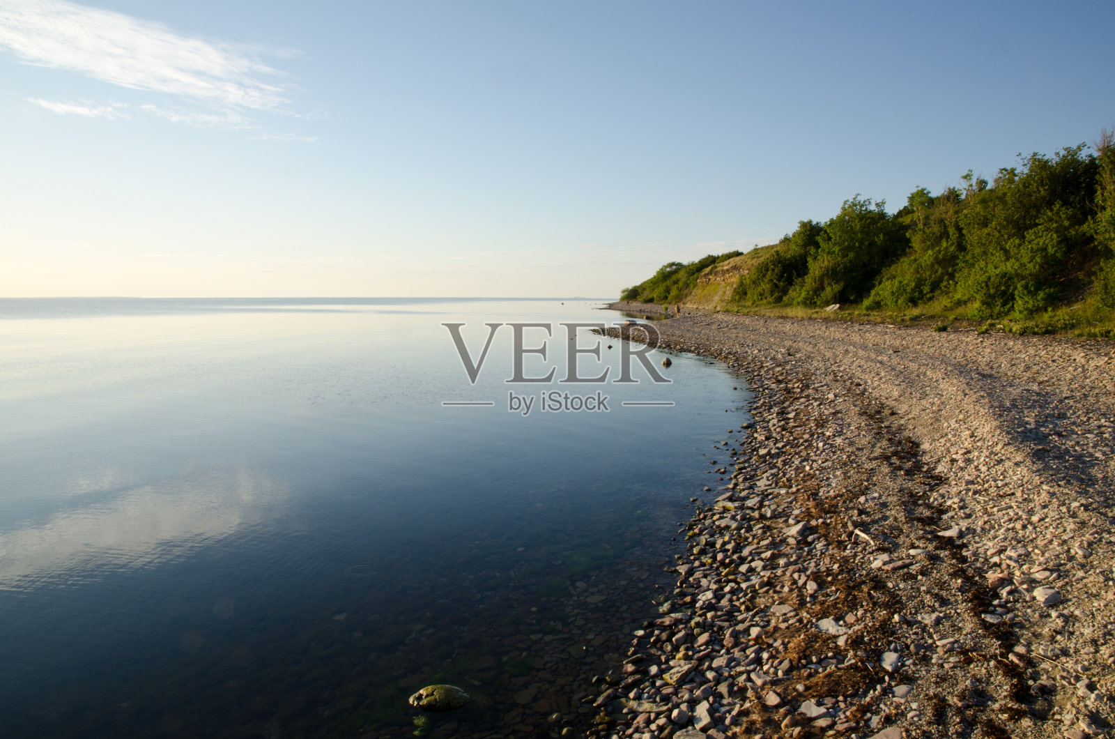 多石的海岸线是一个平静而明亮的夏夜照片摄影图片