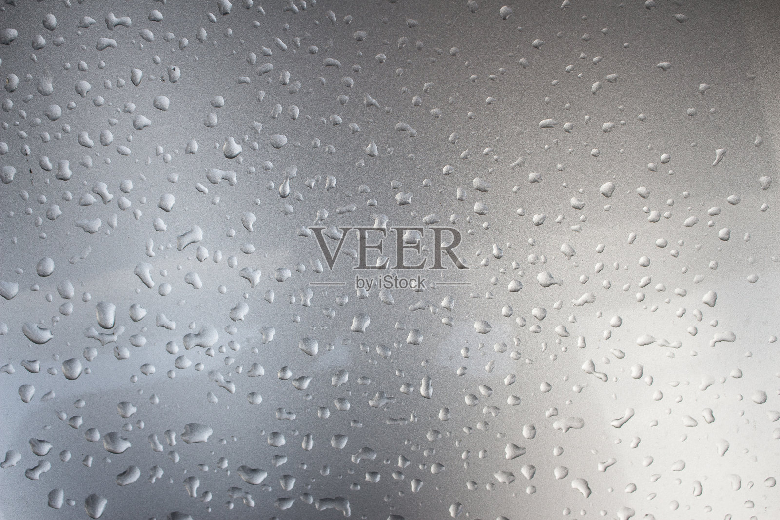 灰色金属背景上的水滴。照片摄影图片