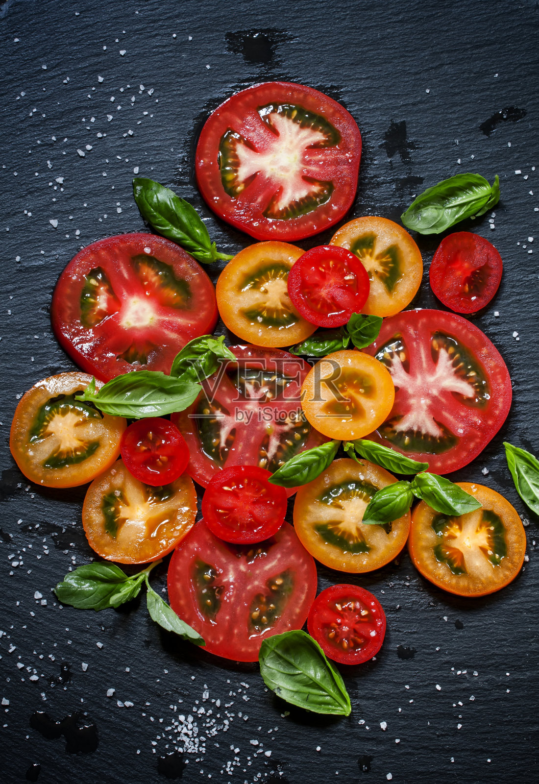 切些有颜色的西红柿和罗勒叶照片摄影图片