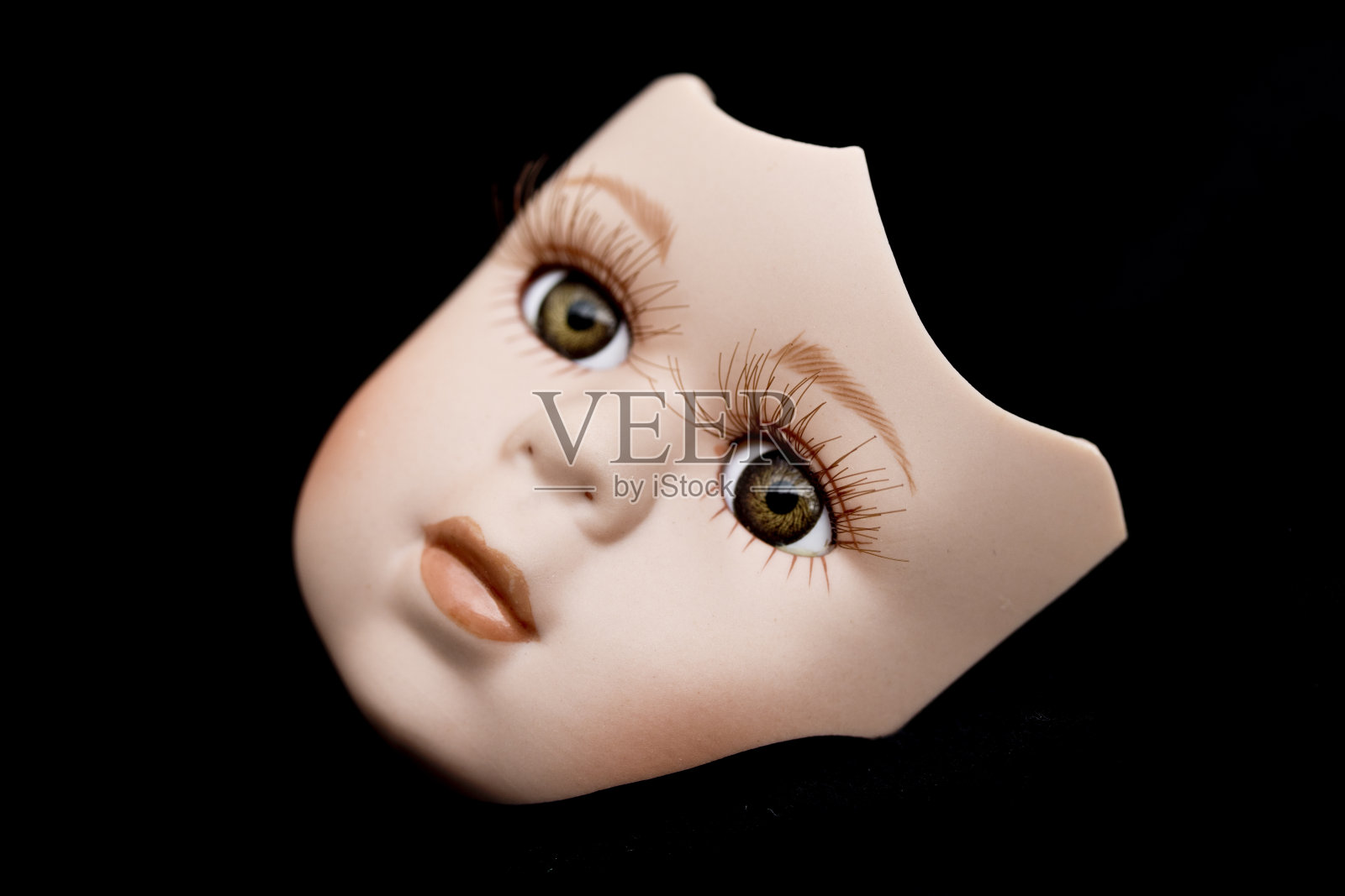 破碎的娃娃脸和头部在黑色的背景照片摄影图片