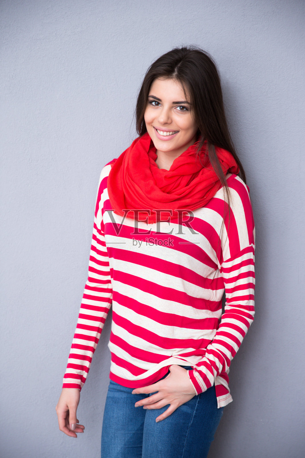 微笑美丽的女人在灰色的背景摆姿势照片摄影图片