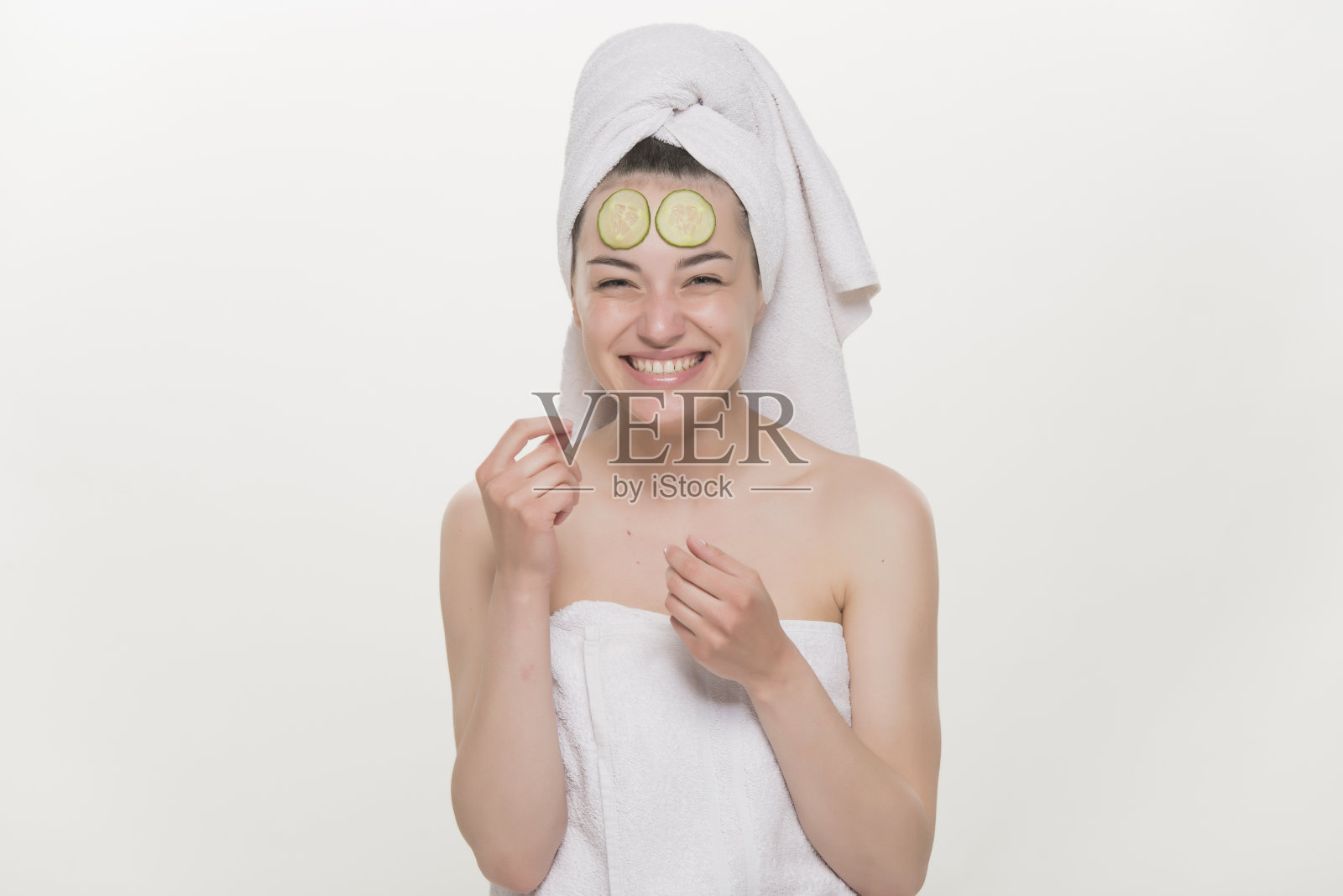 漂亮的年轻女子接受黄瓜面膜照片摄影图片