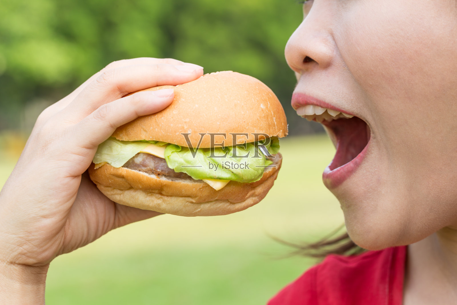 亚洲女人吃汉堡照片摄影图片