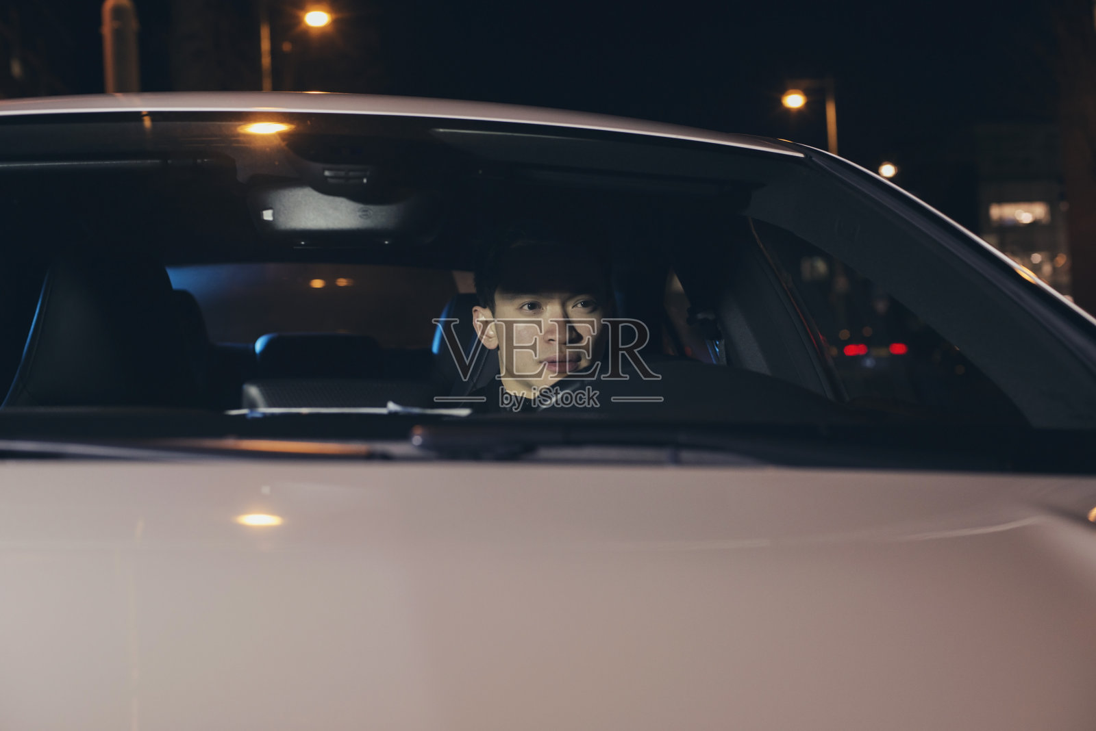 晚上开车的亚洲男人。照片摄影图片