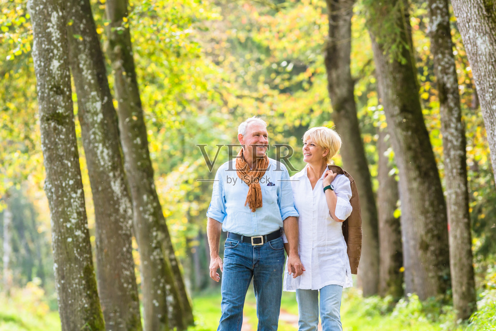 一对老年夫妇在树林里散步照片摄影图片
