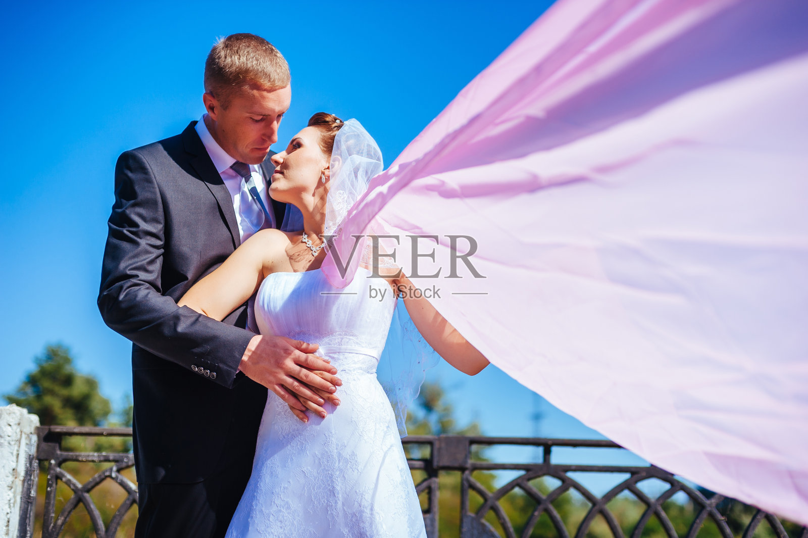 新婚夫妇。风吹起长长的婚纱。新娘照片摄影图片