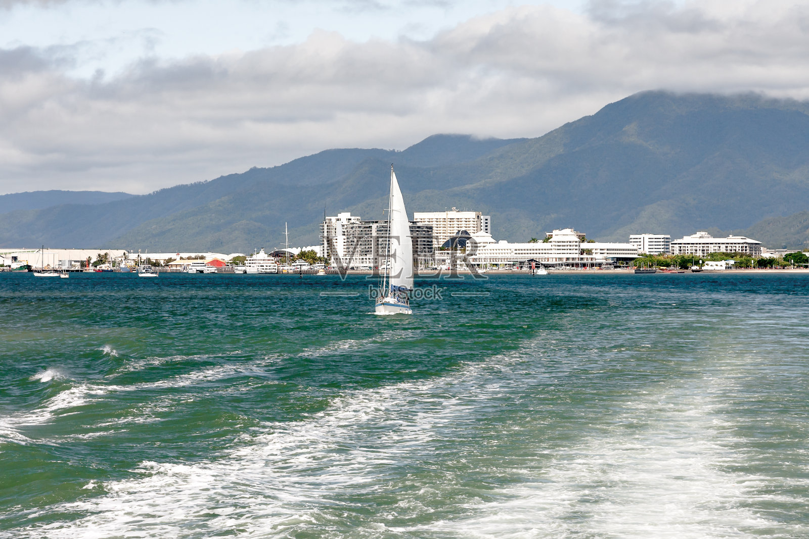 欣赏城市海岸线的山脉，云彩和航行。照片摄影图片