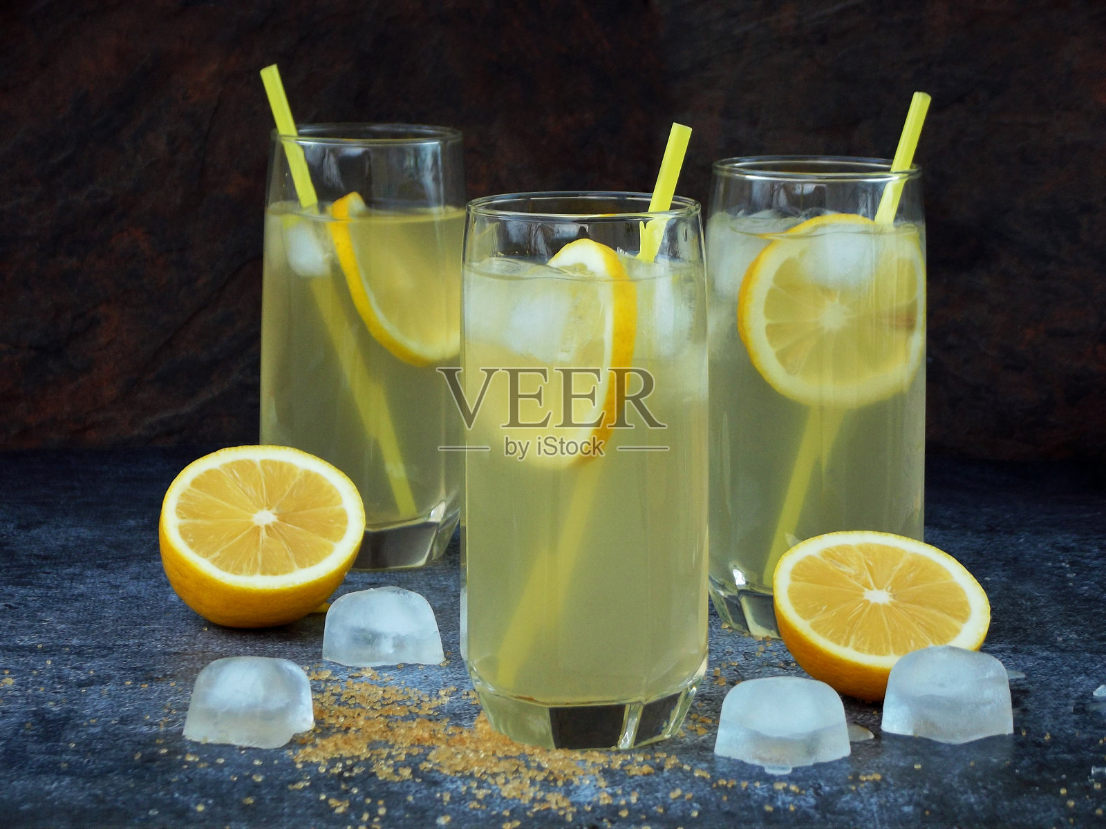 三杯自制冷柠檬水，加柠檬片，冰块，红糖和吸管照片摄影图片