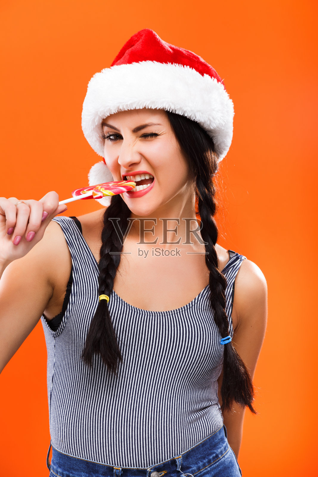 黑发女孩与彩色糖果摆姿势在工作室照片摄影图片