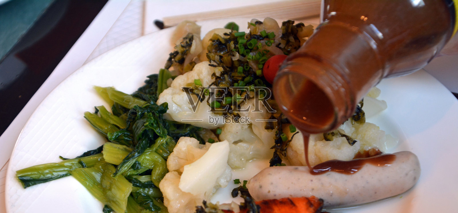 盘子里的日本美食。香肠，芥末和蔬菜。照片摄影图片