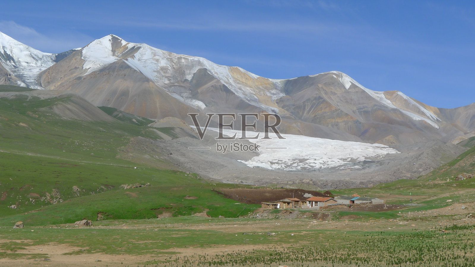 西藏的小村庄和神圣雪山上的冰川照片摄影图片