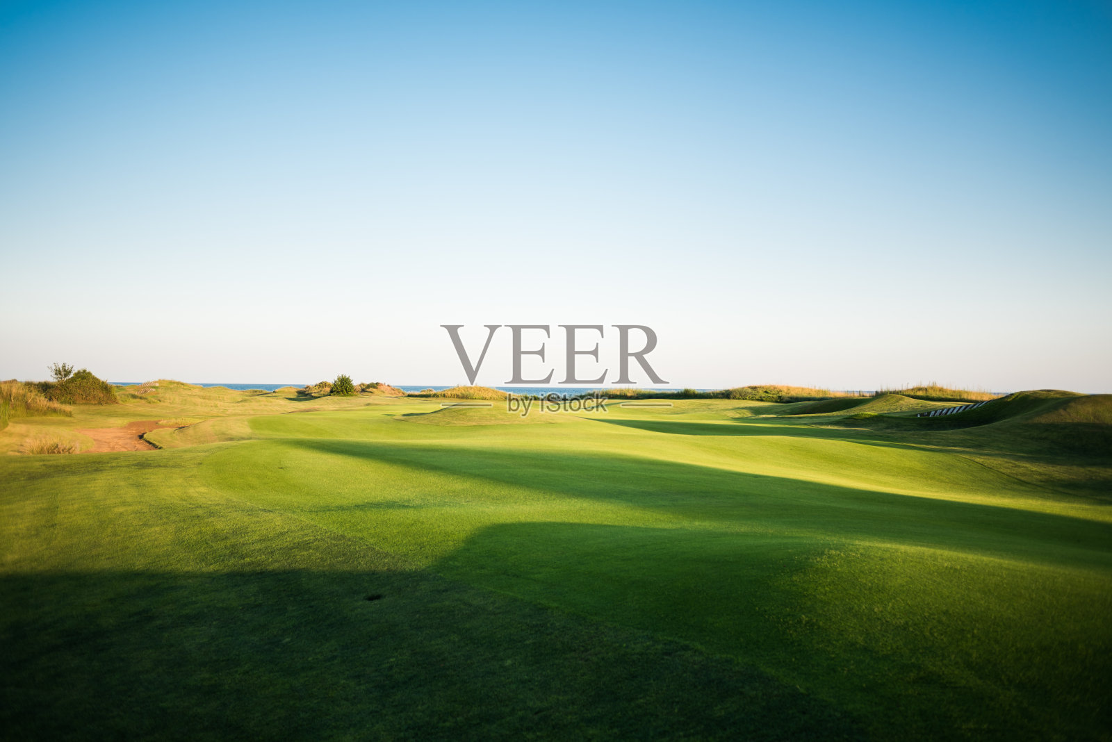 日落时分带沙坑的高尔夫球场照片摄影图片