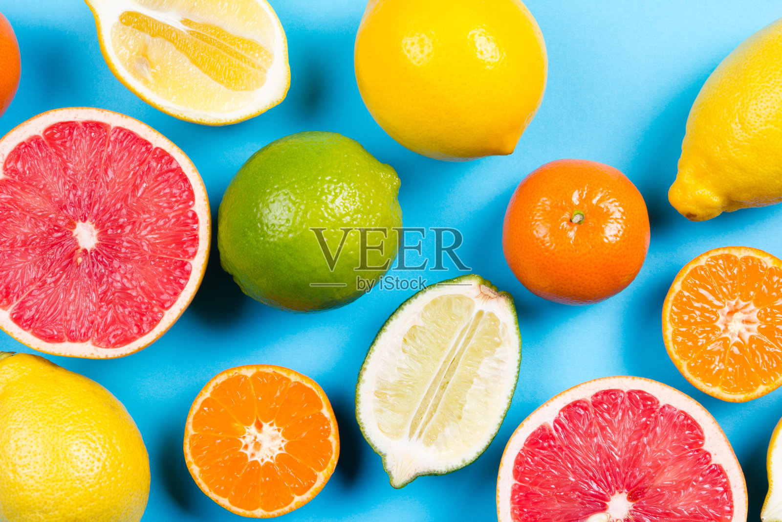 蓝色背景下的几种完整的和切开的柑橘照片摄影图片