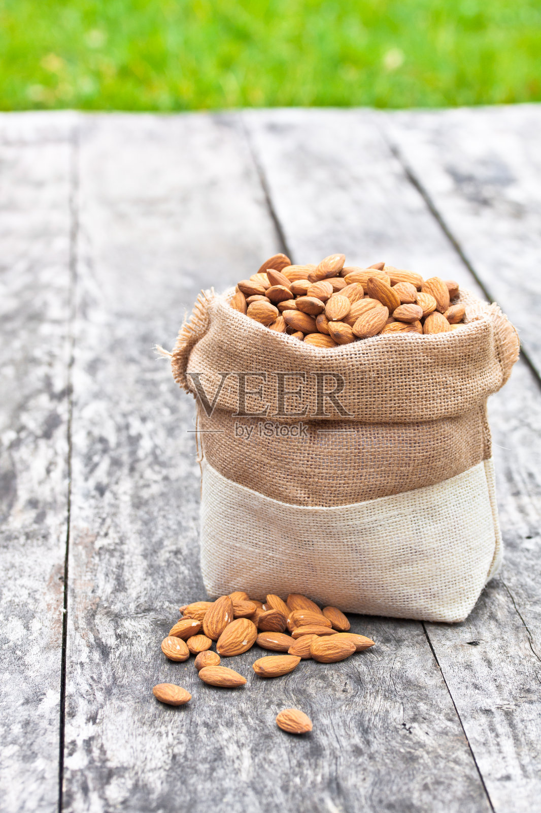 旧桌子上放着杏仁袋，还有绿草照片摄影图片