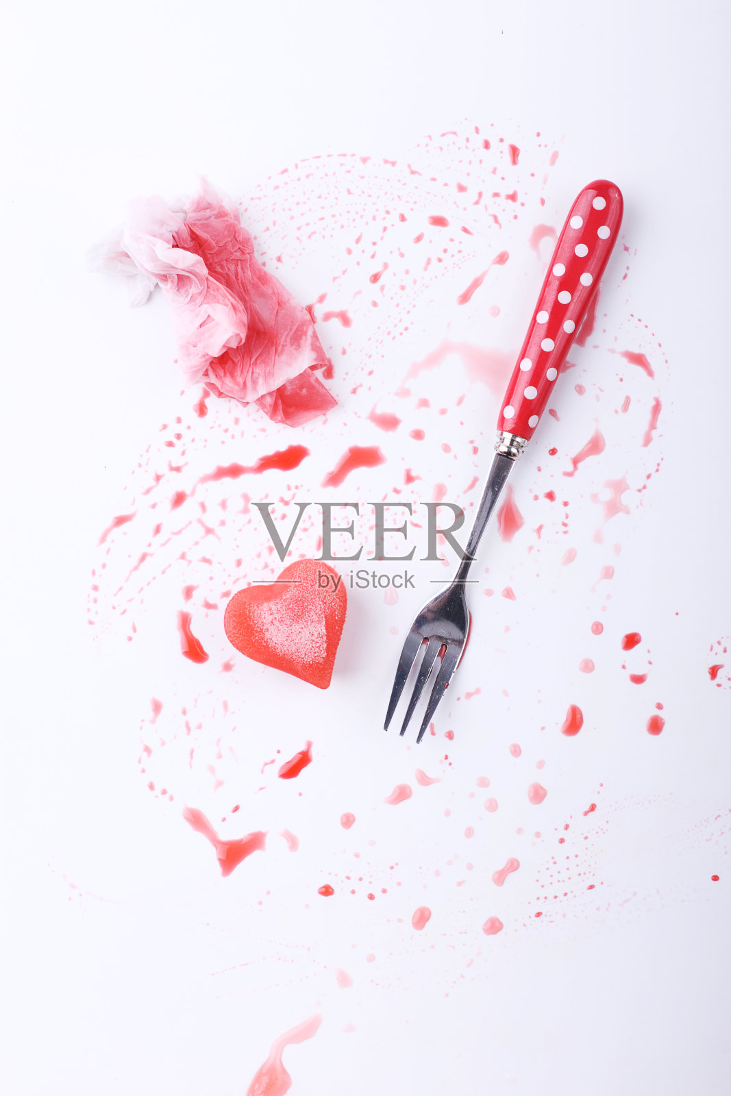 红色的心形冰，用银叉从覆盆子糖浆中取出照片摄影图片