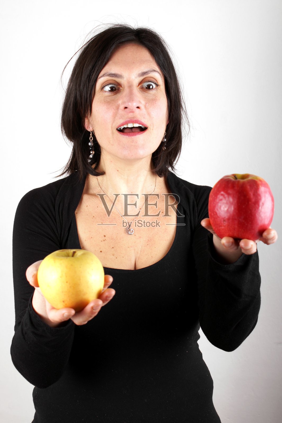 一个穿着黑衣服拿着苹果的女人的肖像照片摄影图片