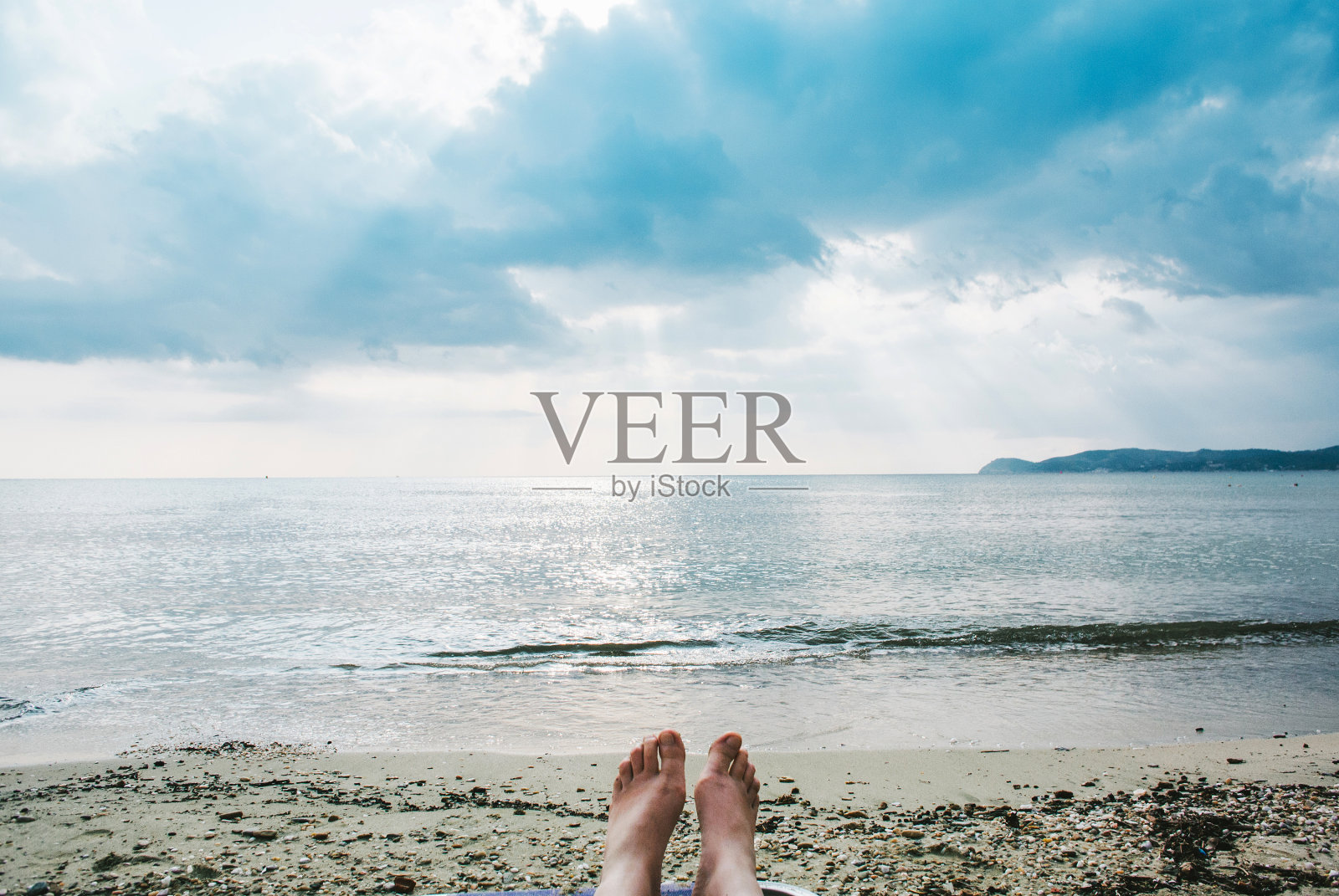 女性的腿和脚日光浴在海滩上照片摄影图片