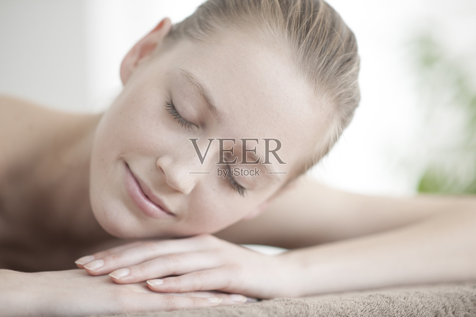 一个年轻女子躺在按摩床上的特写镜头照片摄影图片