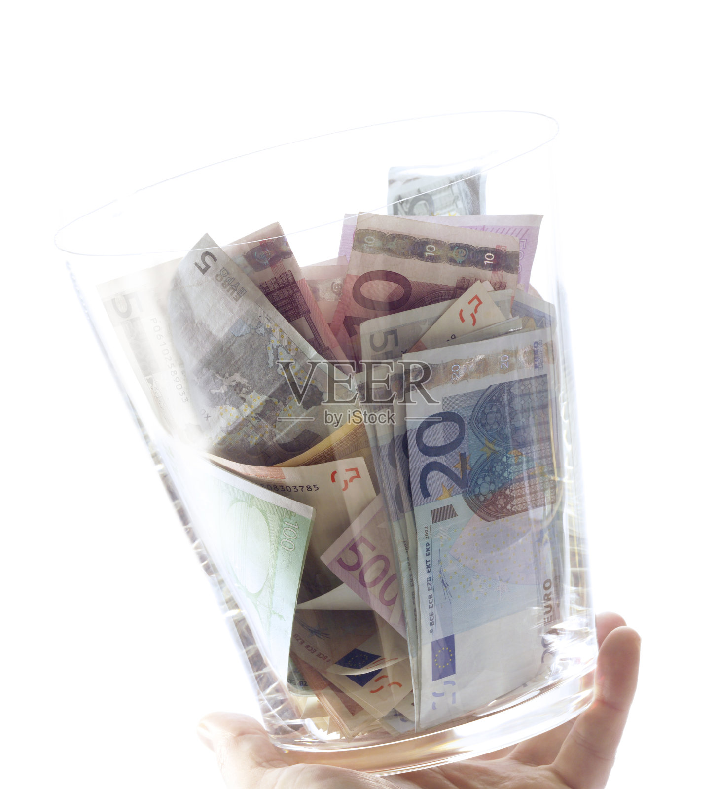 拿着带钱的玻璃杯，特写照片摄影图片