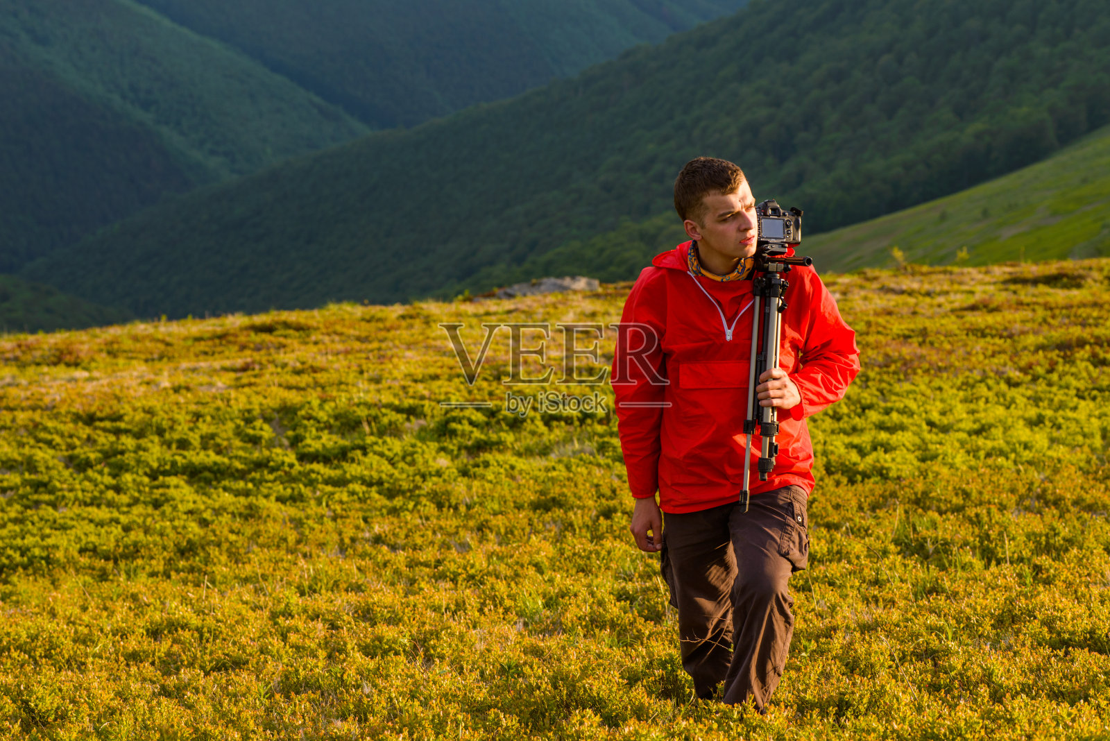 摄影师拿着三脚架和照相机照片摄影图片