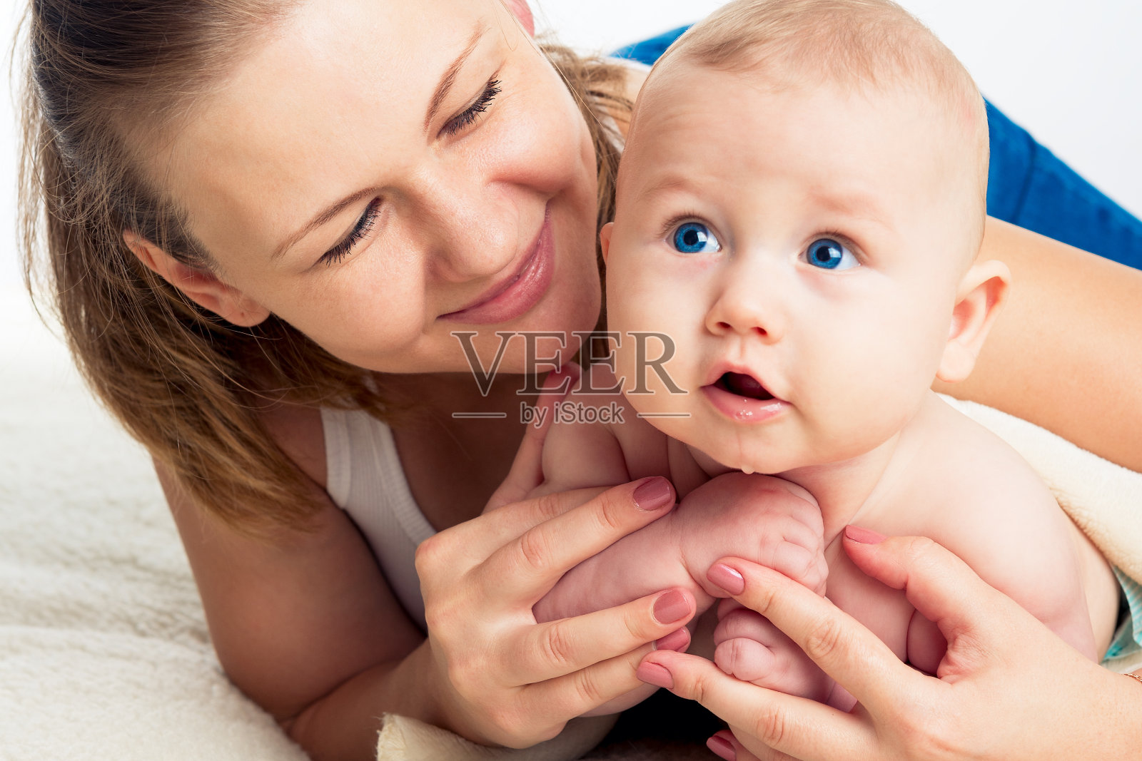 美丽微笑的年轻母亲与婴儿的肖像。照片摄影图片