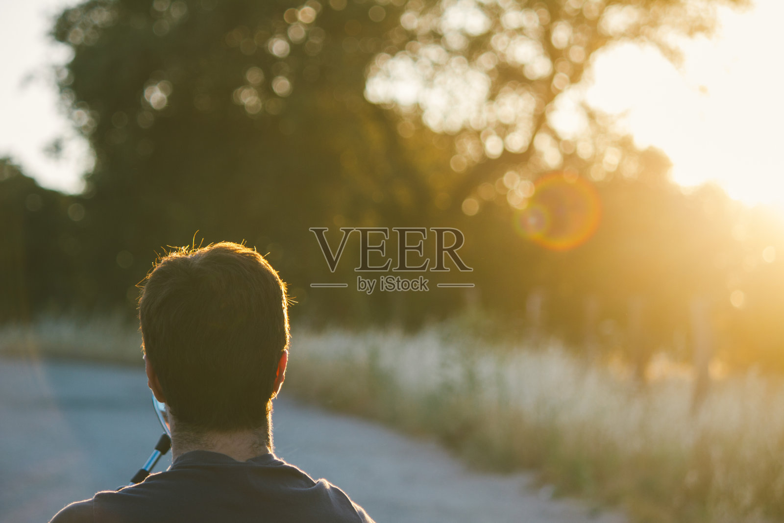 一个男人坐在摩托车上的背光照片摄影图片