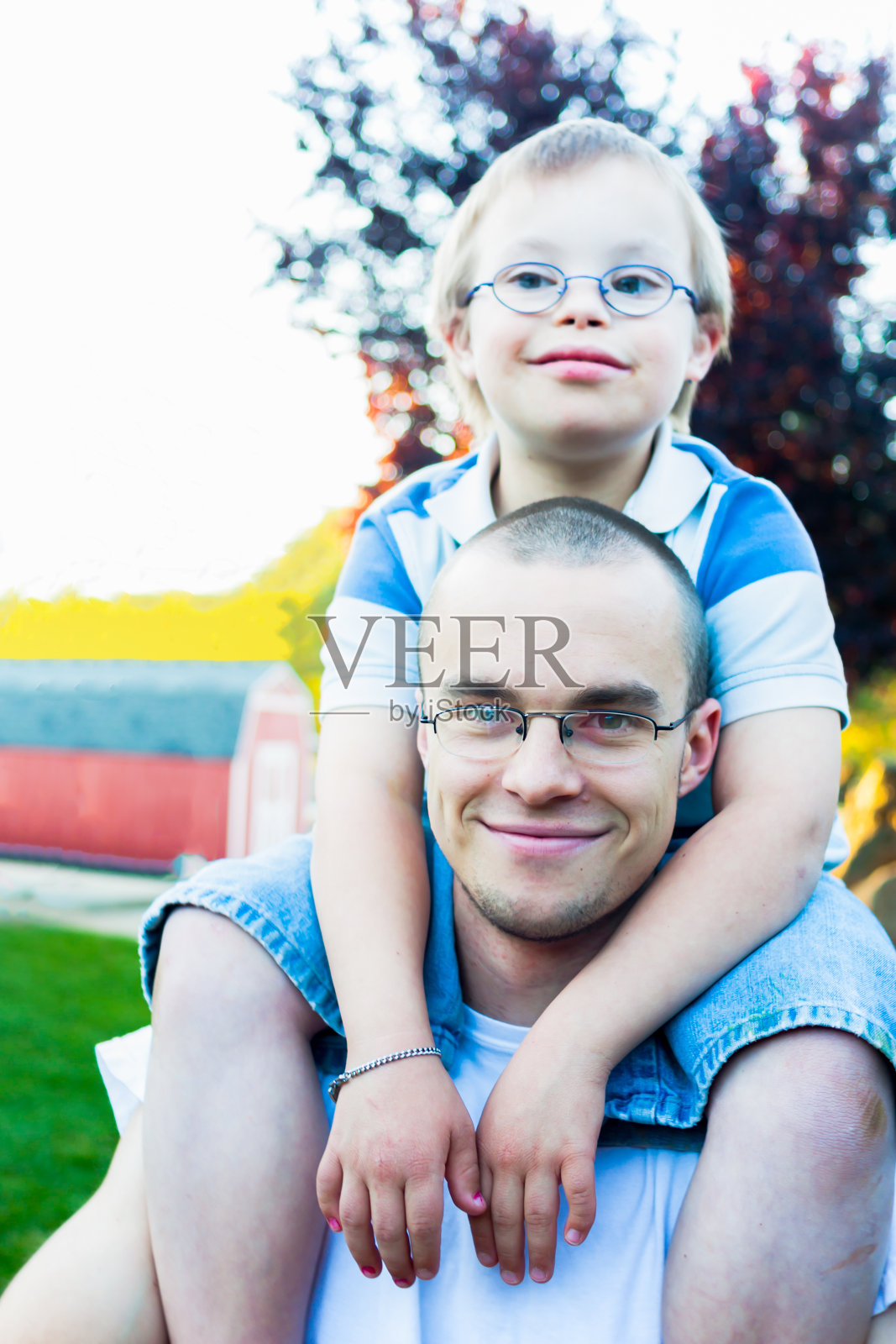 患有唐氏综合症的弟弟坐在哥哥的肩膀上照片摄影图片