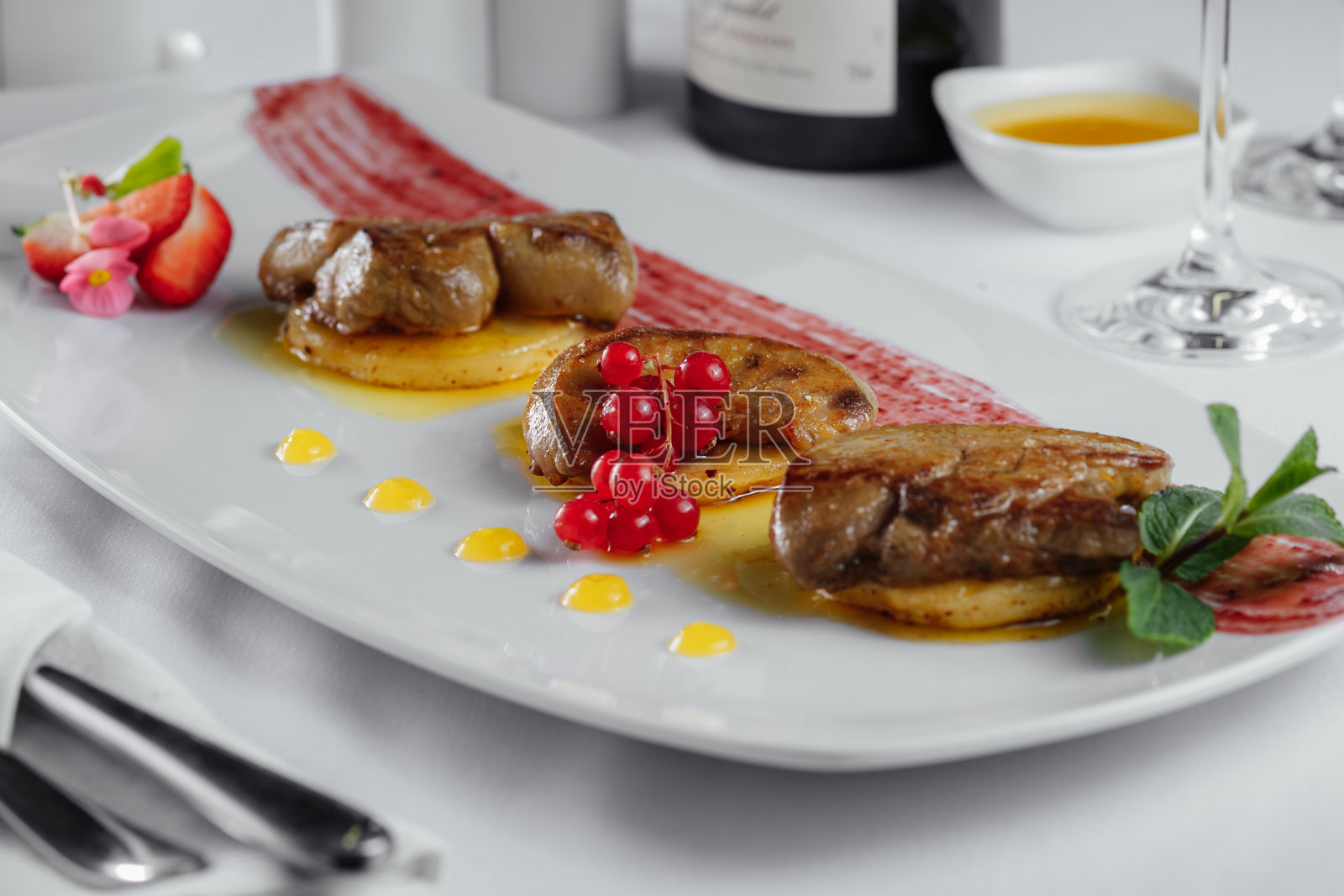 肉土豆片加醋栗，酱汁放在白色盘子里照片摄影图片