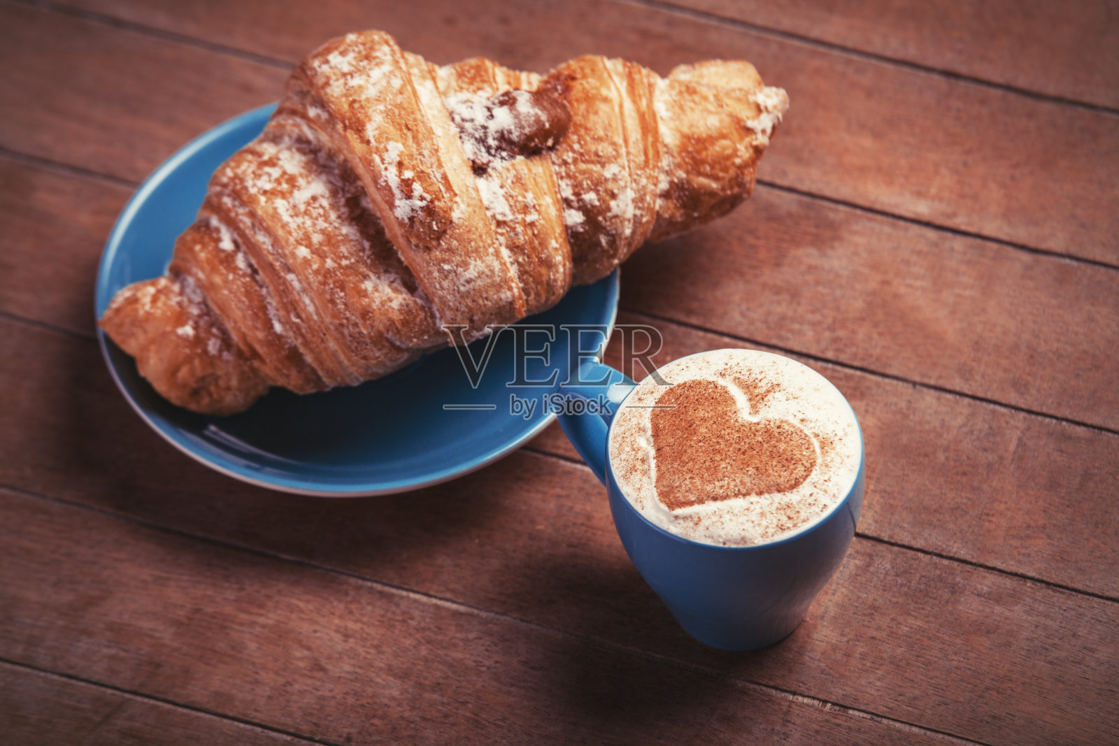 一张木桌上放着法式羊角面包和一杯咖啡照片摄影图片