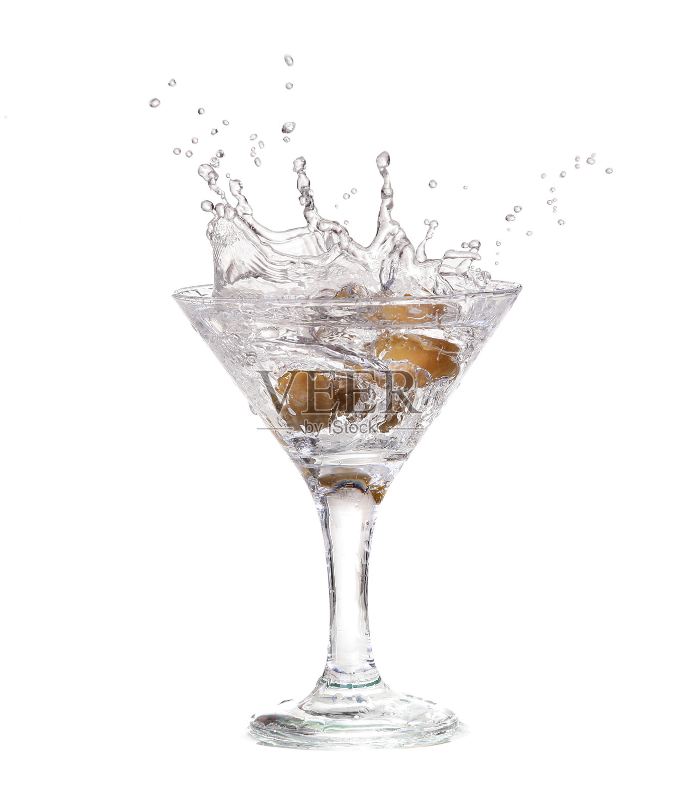 将橄榄倒入一杯鸡尾酒中照片摄影图片