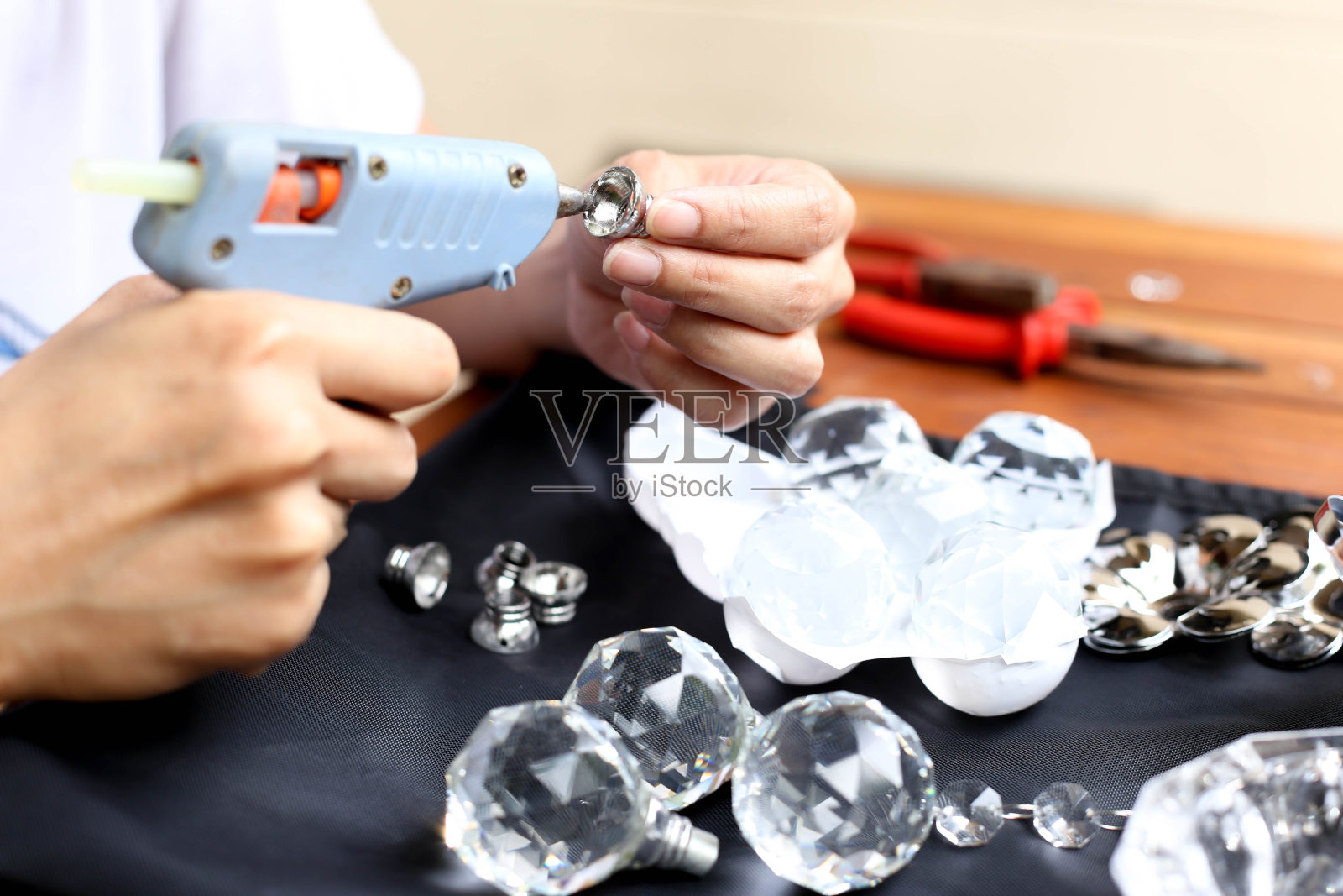 用胶枪修理水晶灯的女人照片摄影图片