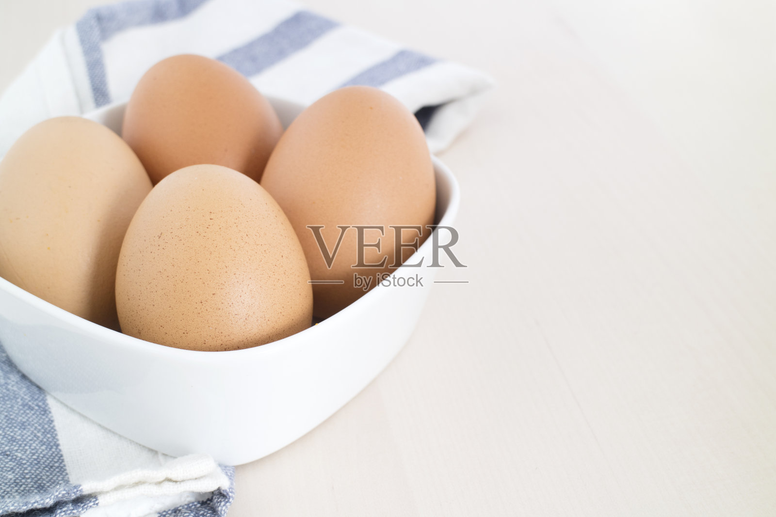 鸡蛋放在白碗里，木盘里照片摄影图片