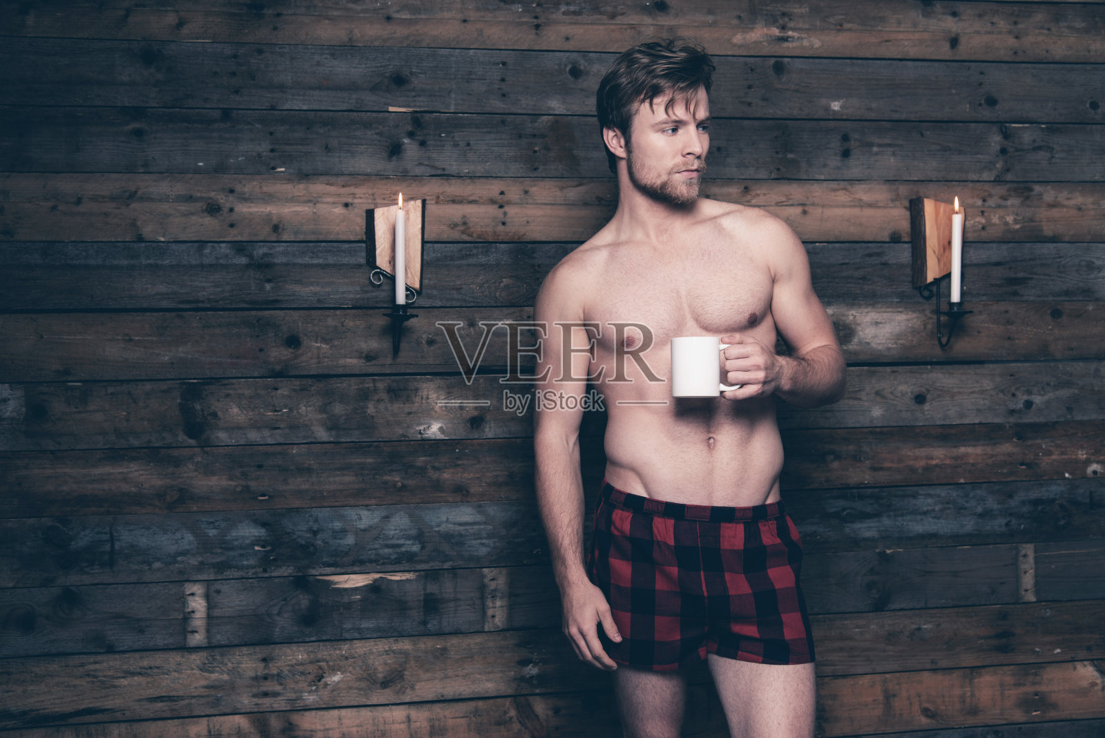 赤裸上身，穿着红色法兰绒短裤的男人。照片摄影图片