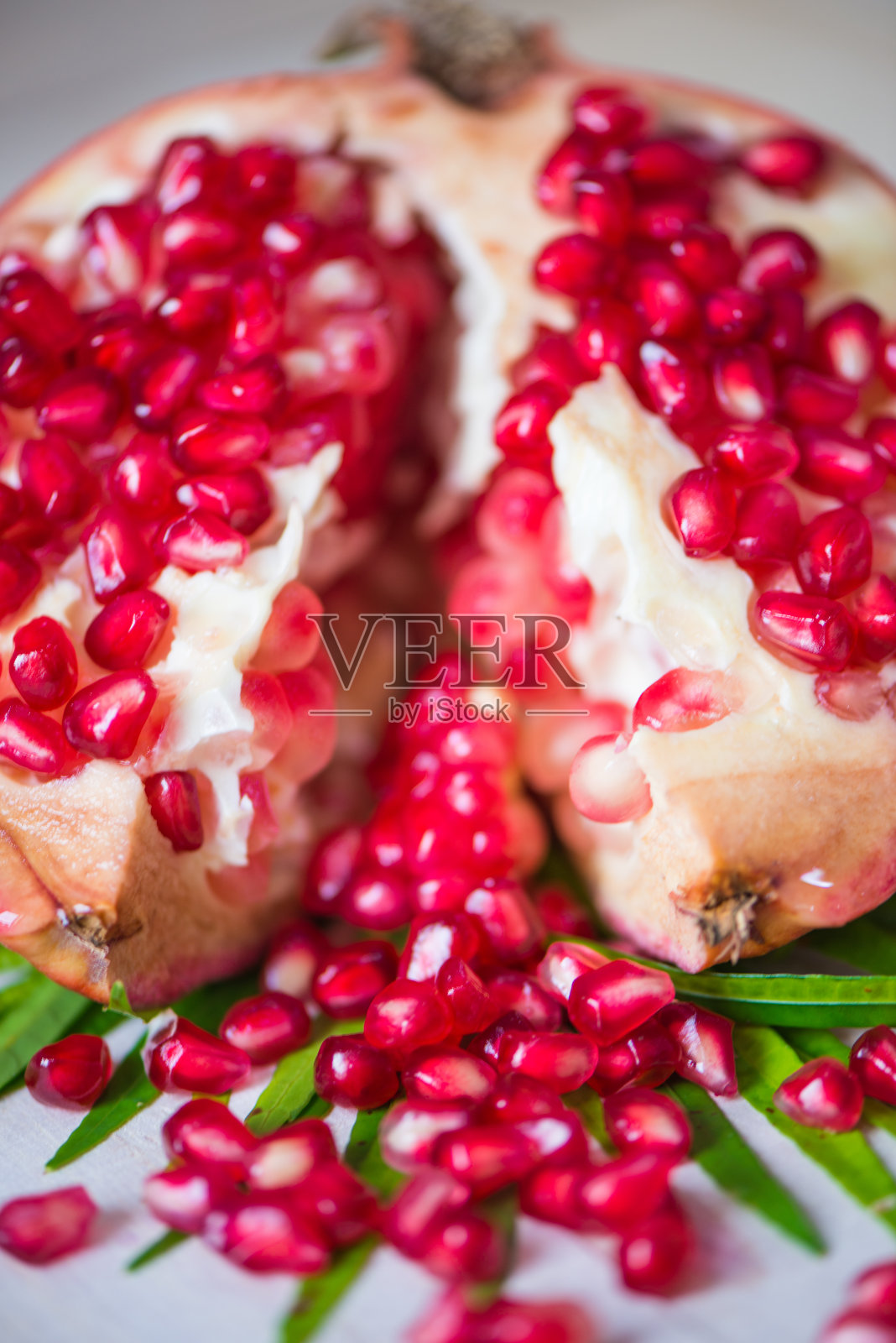 多汁的石榴和一半的叶子照片摄影图片