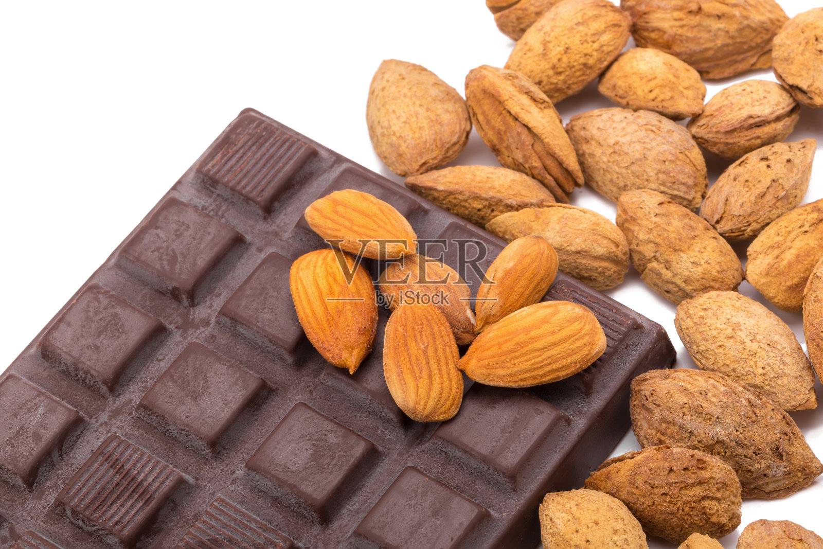 白色背景下分离出杏仁和黑巧克力。照片摄影图片