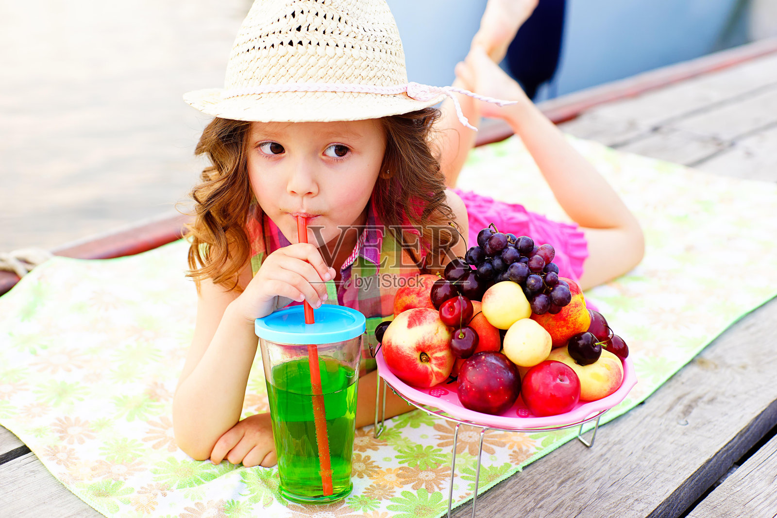 小女孩在码头上喝着闪闪发光的水照片摄影图片