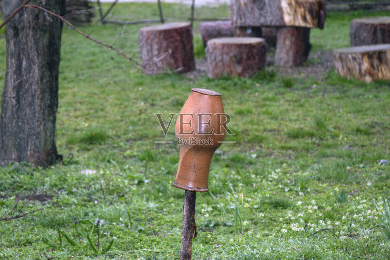 牛奶罐挂在院子的旧篱笆上照片摄影图片