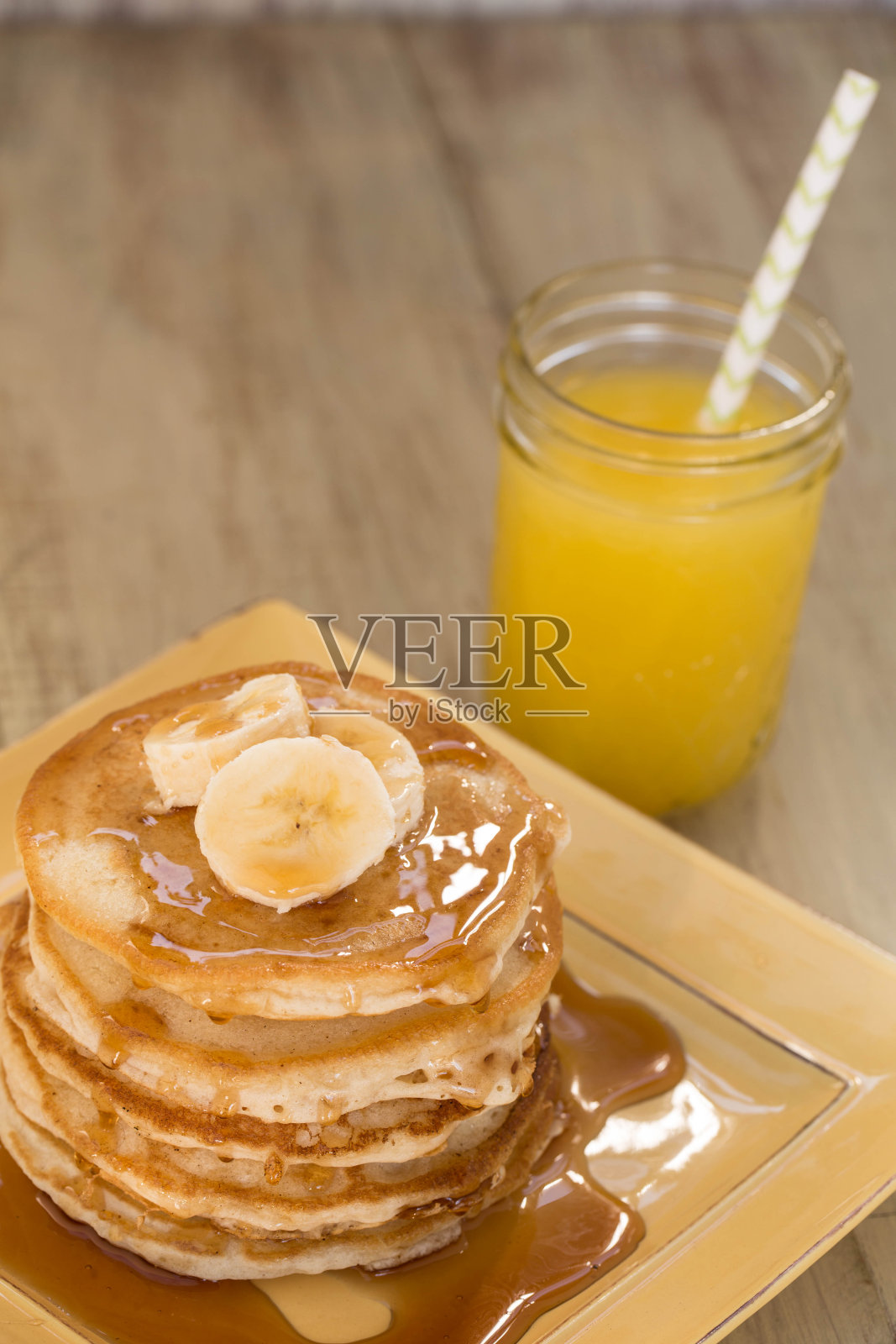 早餐酪乳煎饼，糖浆和新鲜橙汁照片摄影图片