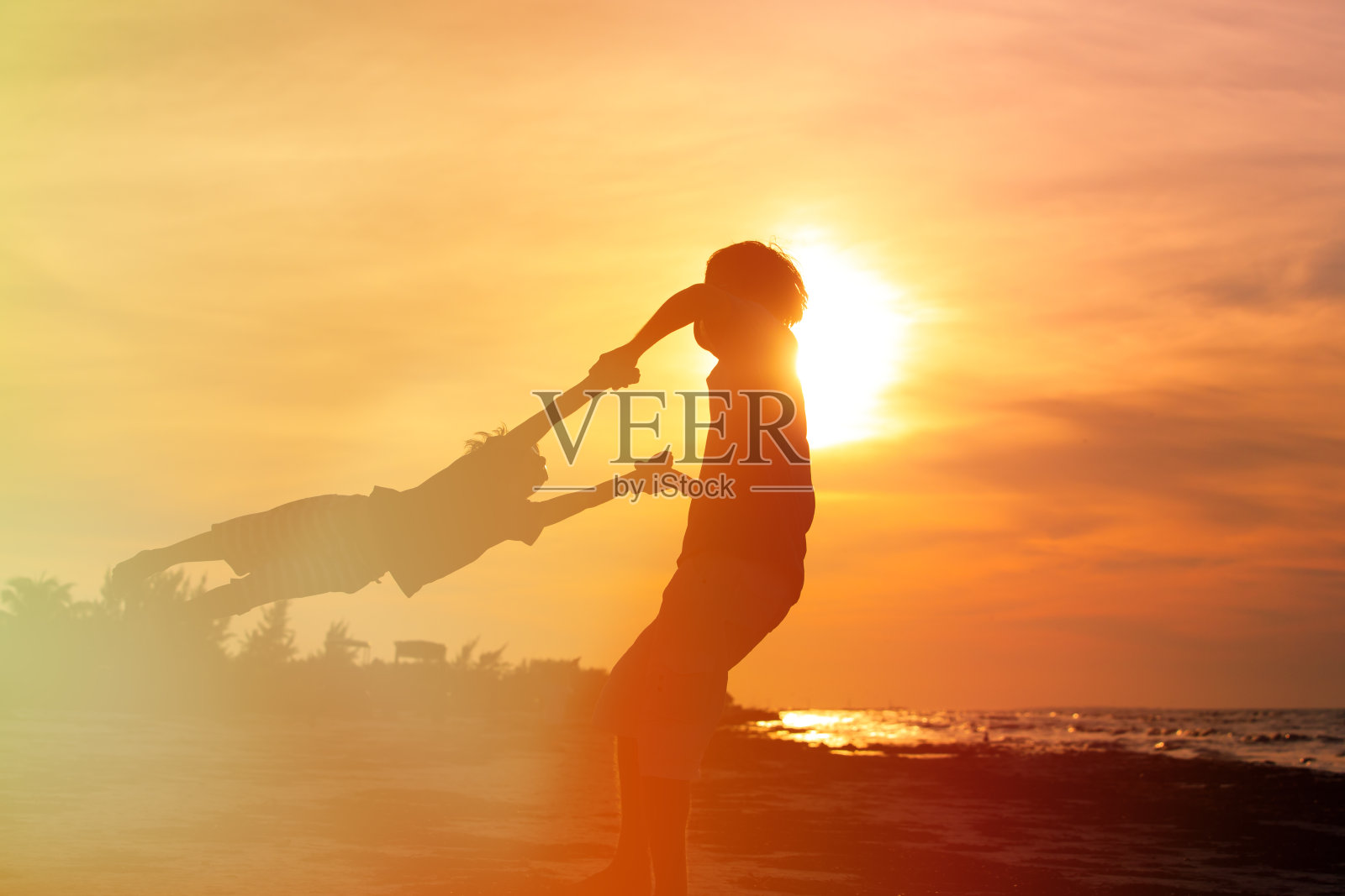 父亲和小儿子在日落时玩耍照片摄影图片