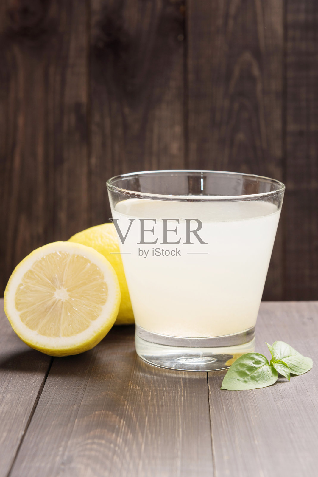 柠檬水和新鲜的柠檬片放在木桌上照片摄影图片