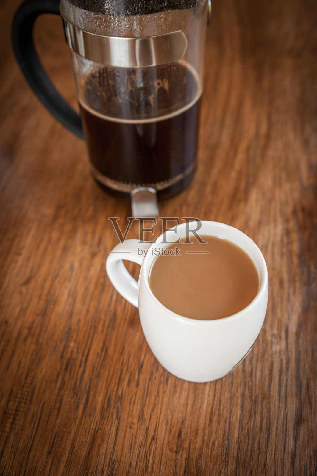 木桌上放着白色咖啡杯和一个活塞照片摄影图片