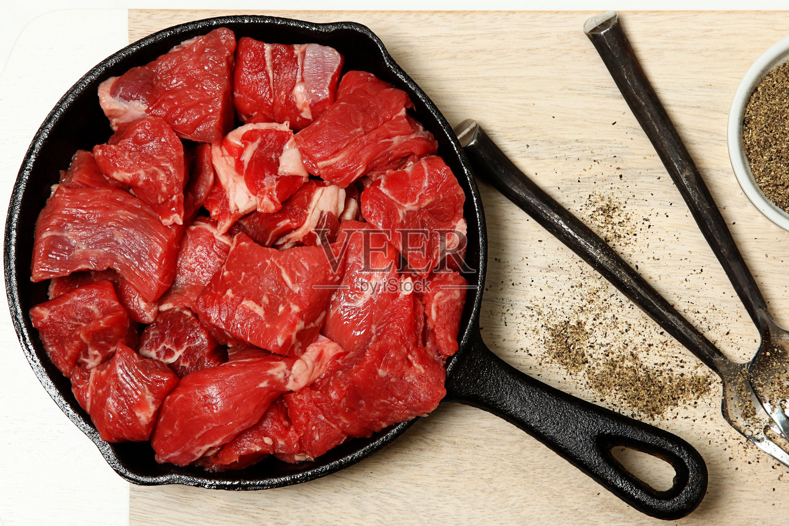生牛肉块在铸铁锅上的桌子照片摄影图片
