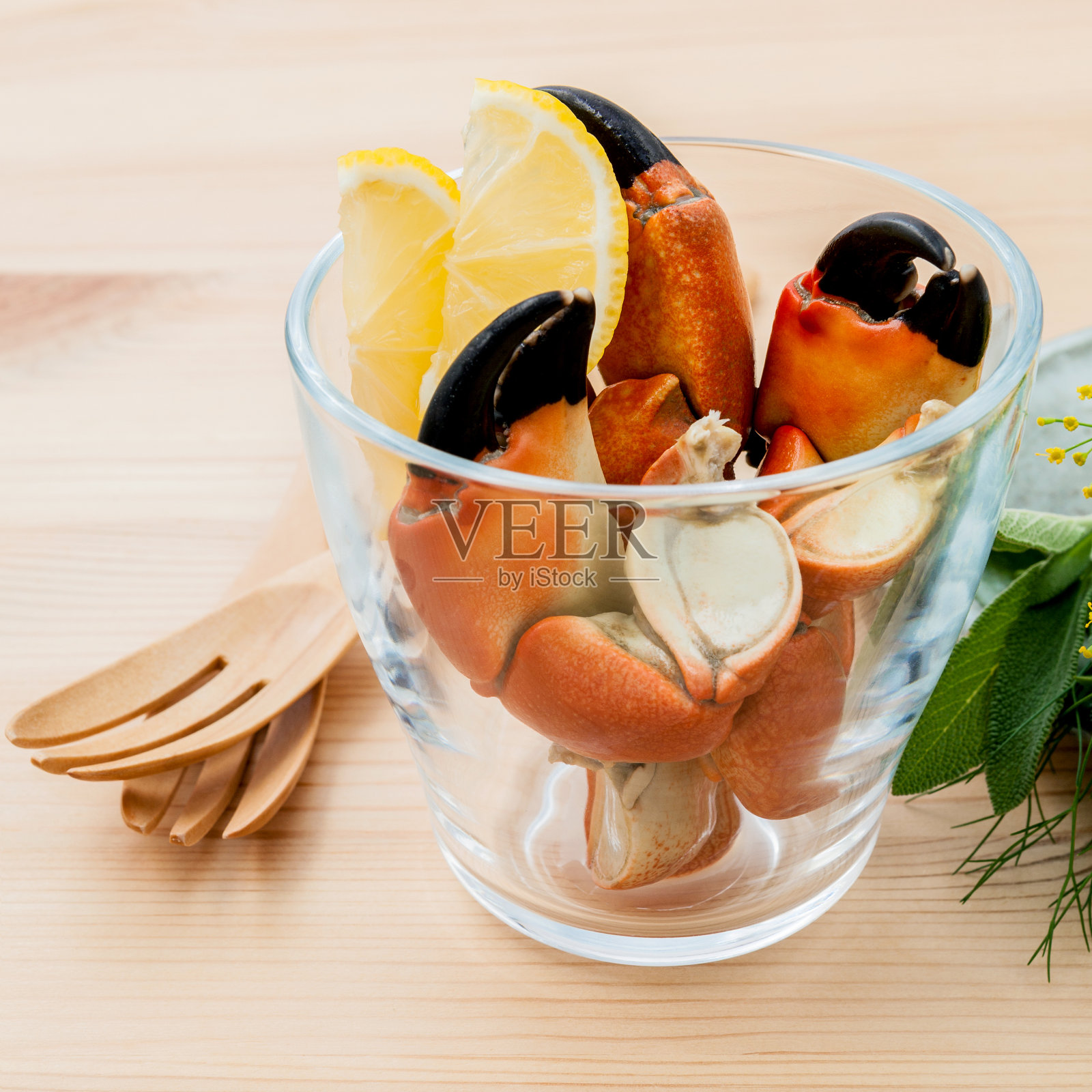 鲜红蒸蟹腿在玻璃碗里。照片摄影图片