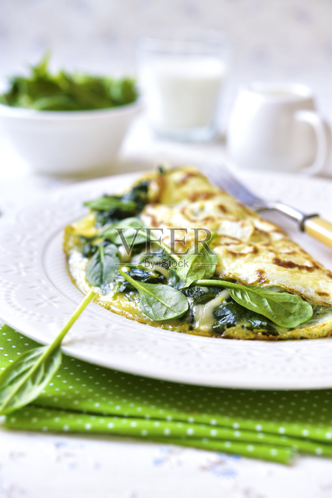 夹有菠菜和奶酪的煎蛋卷。照片摄影图片