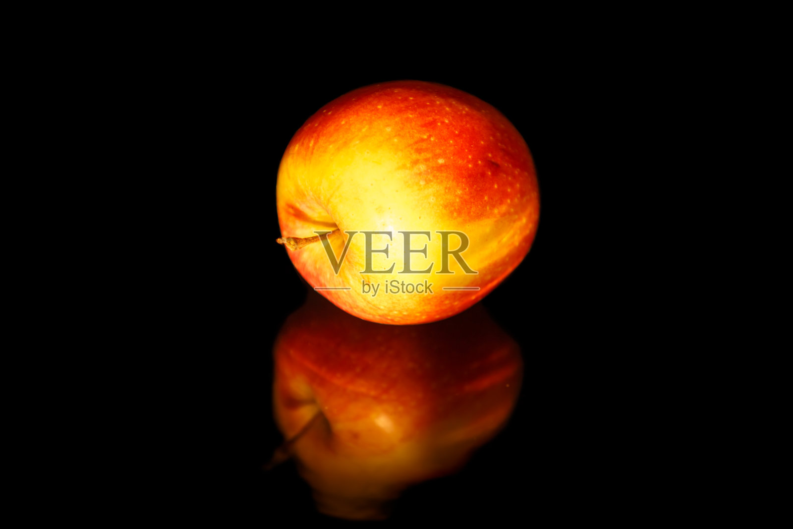 黑色波浪镜上的苹果。照片摄影图片