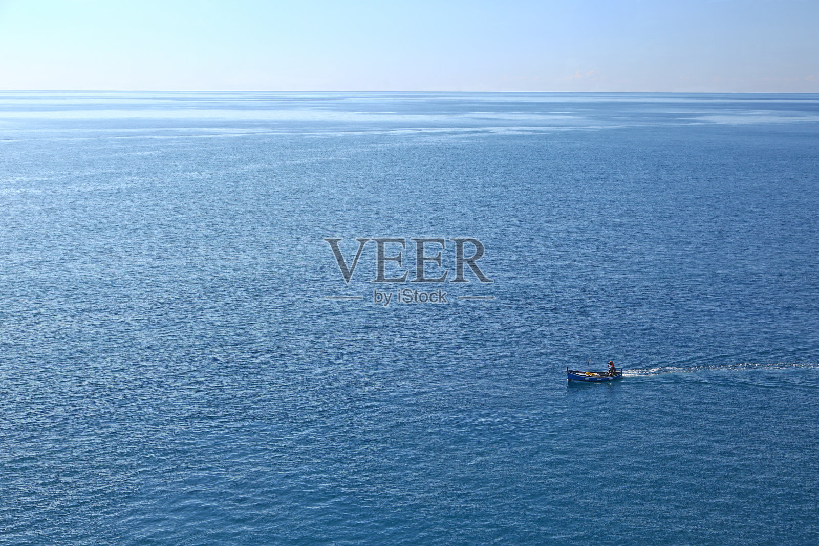 小渔船在平静的大海中航行照片摄影图片