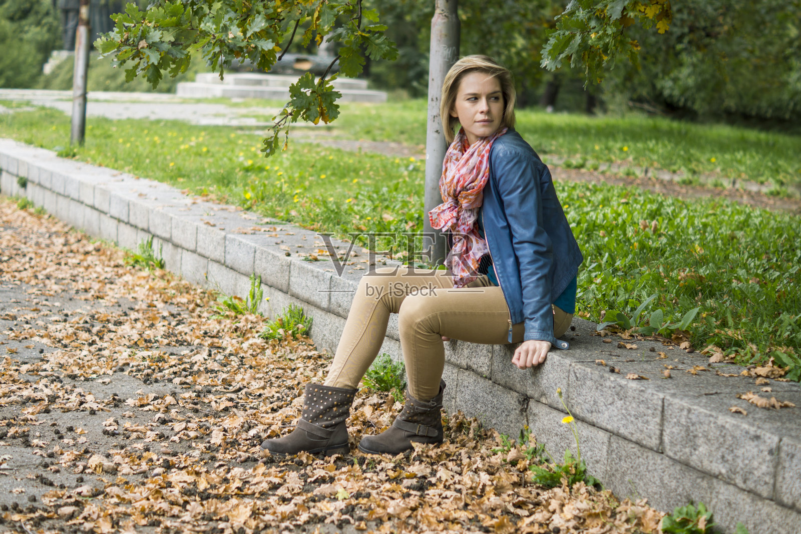 美丽的女孩坐在公园里照片摄影图片