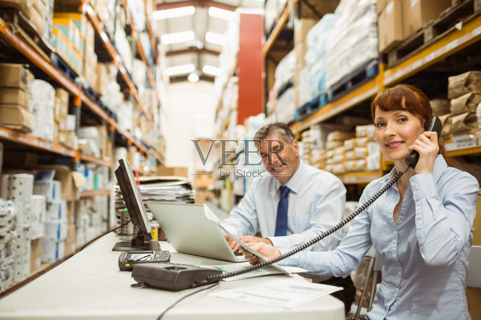 经理使用笔记本电脑和电话工作照片摄影图片